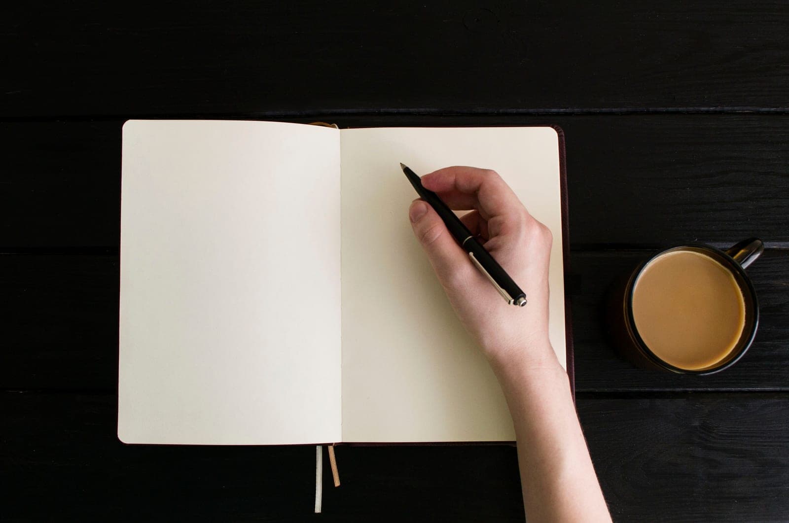 A blank notebook and pen on a desk