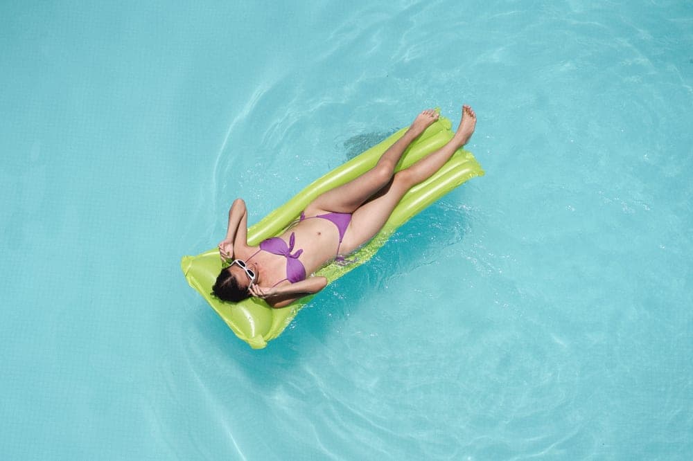 A person relaxing on a float in a swimming pool