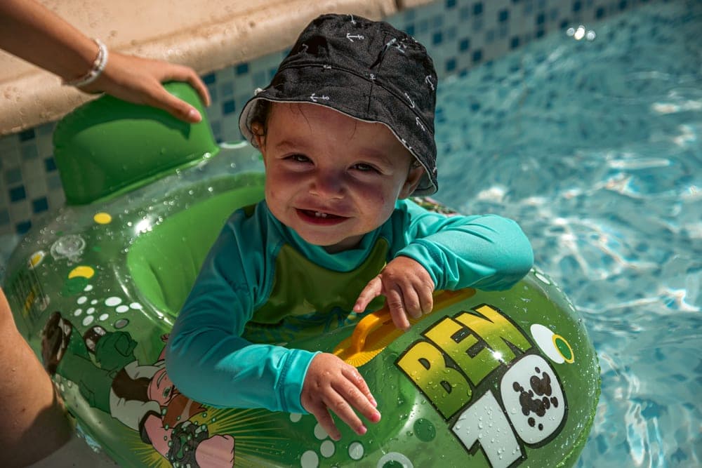 A young child in a swimming pool wearing arm bands