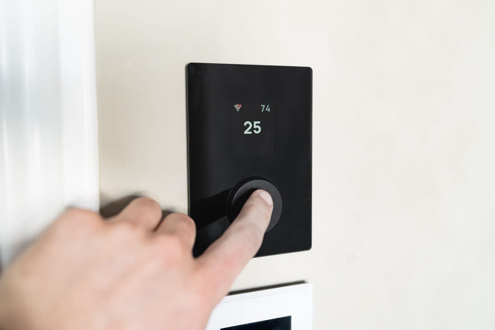 A thermostat control mounted on a wall