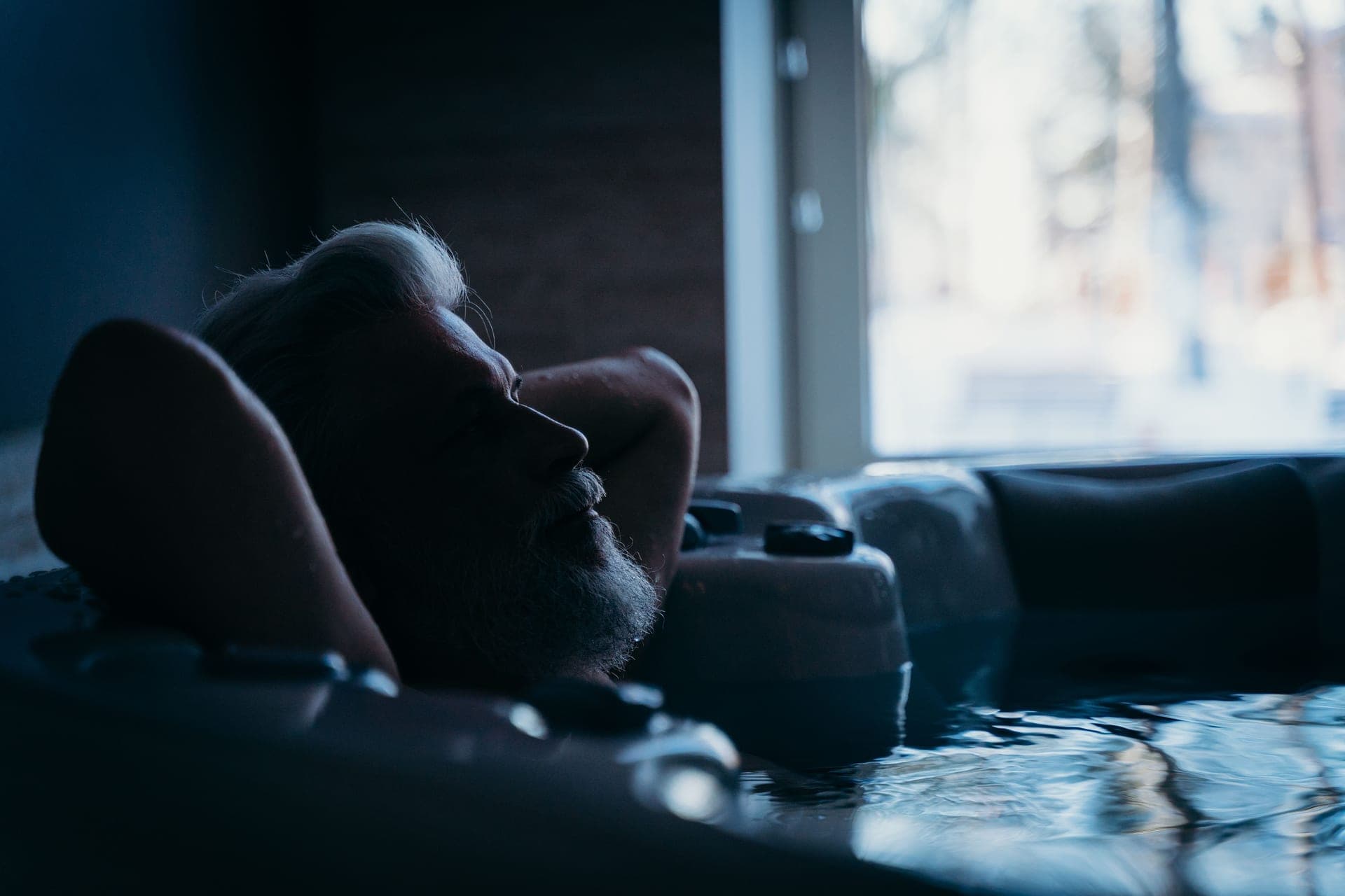 A person relaxing in a hot tub with their eyes closed