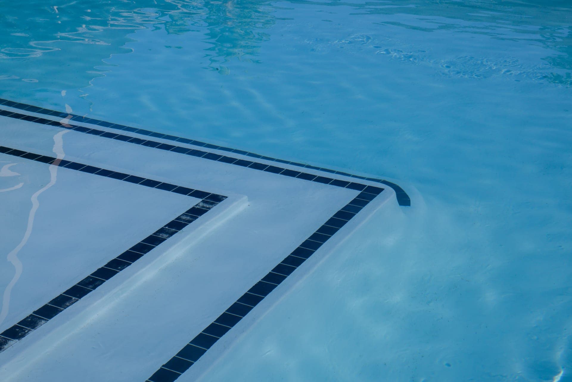 Tiled steps descending into clear blue pool water