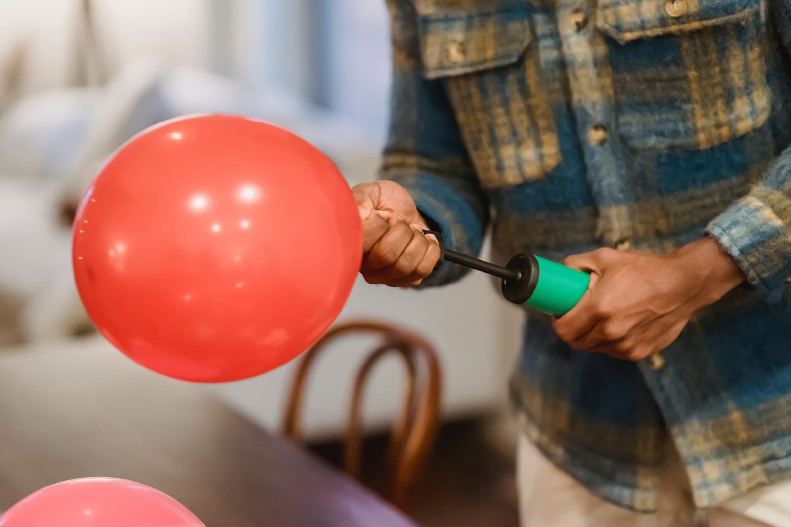 A hand pump being used to inflate a balloon