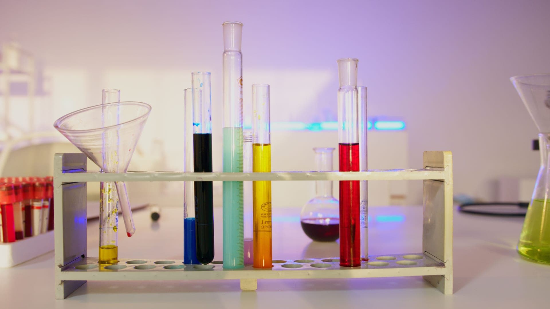 A rack of test tubes filled with colored liquids in a laboratory