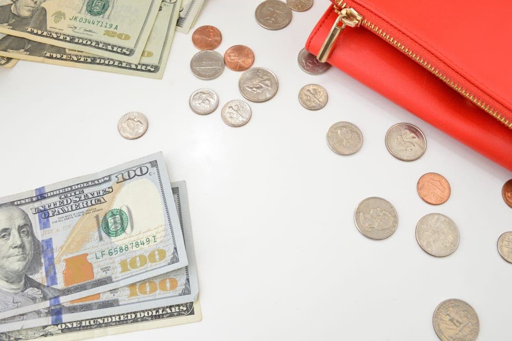 US dollar bills and coins spread across a table