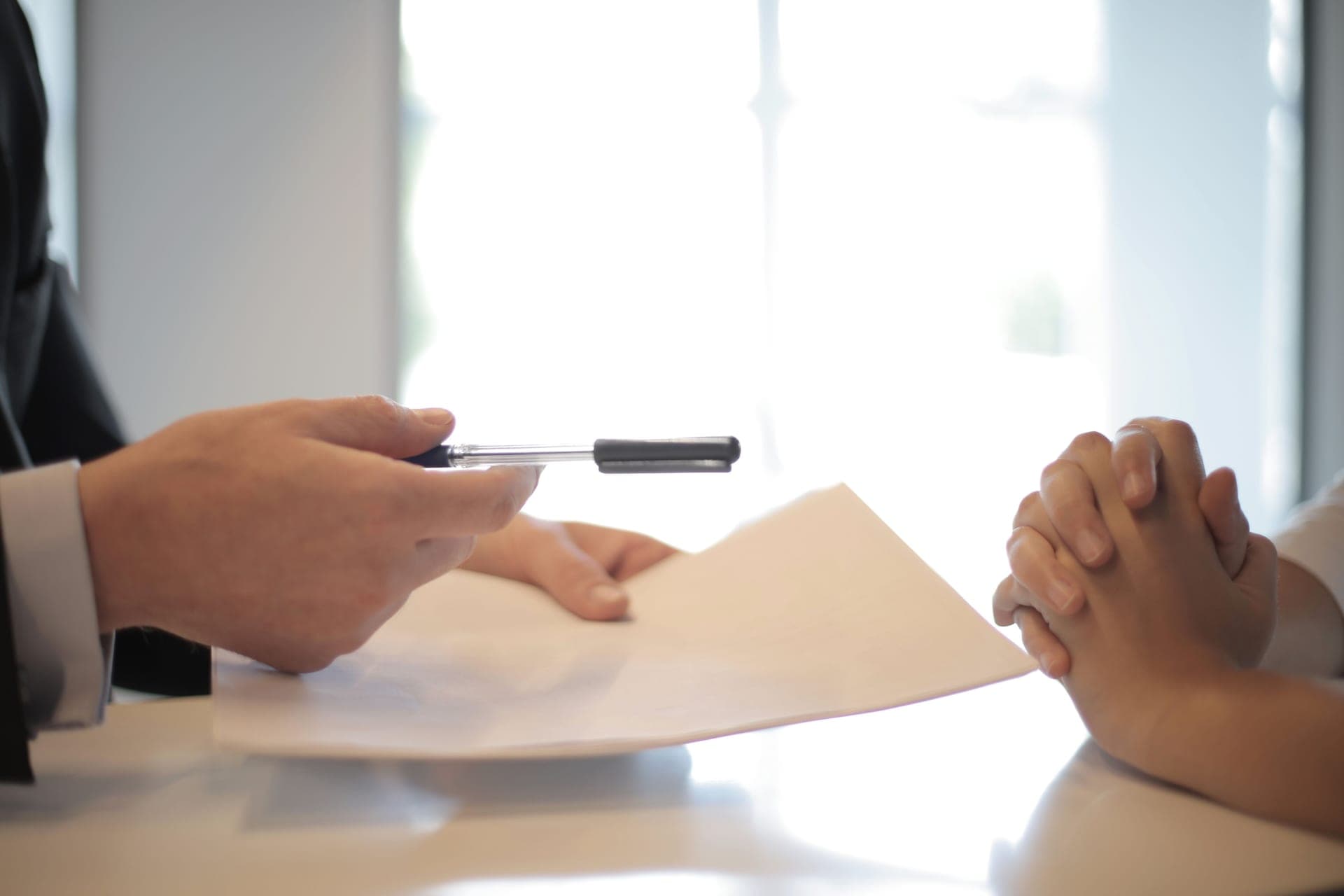 Two people signing paperwork at a desk