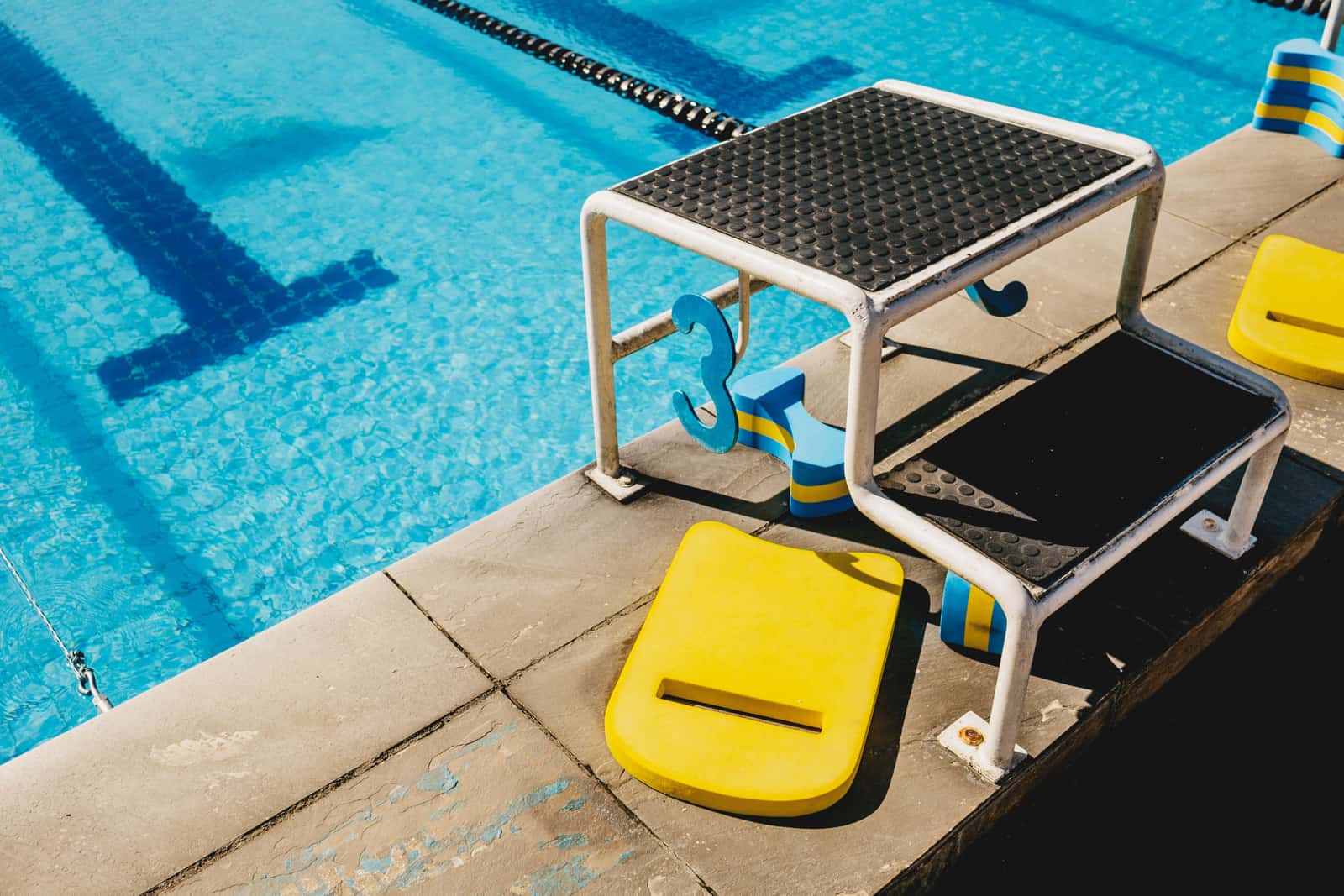 A pool pump and filter unit standing beside a swimming pool