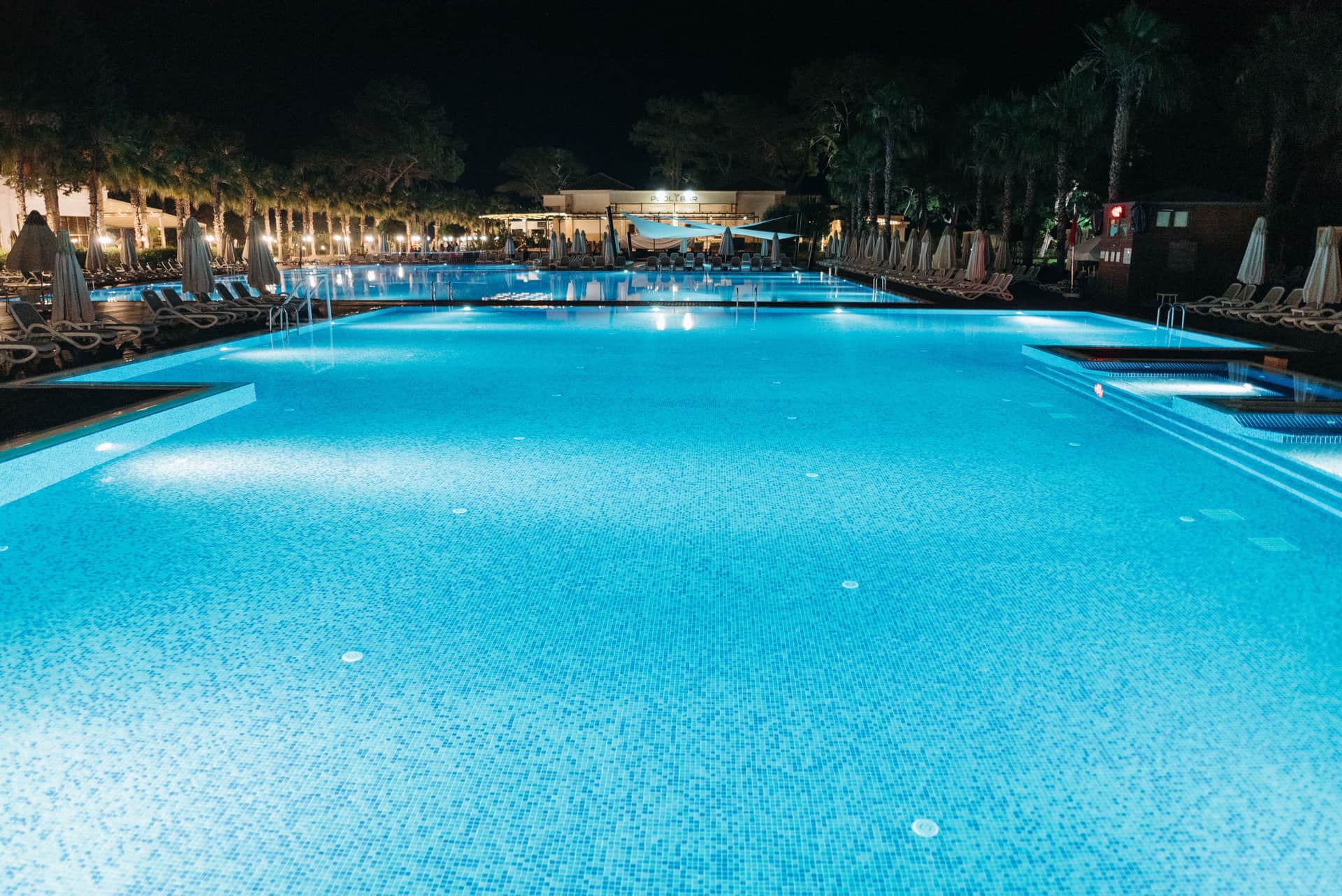 A resort swimming pool illuminated at night