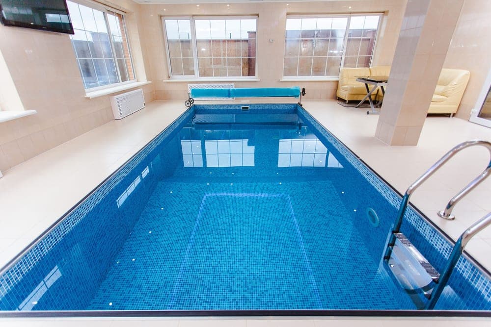 A cover stretched across the blue water of a swimming pool