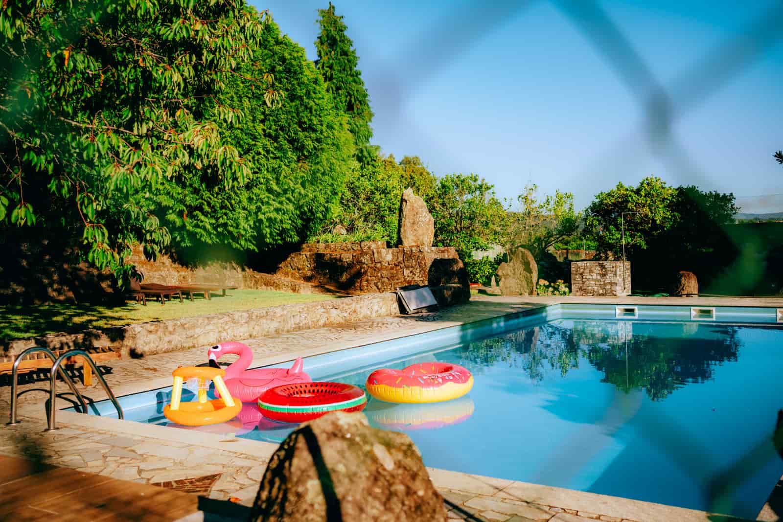 Sunlight reflecting off a swimming pool in a garden