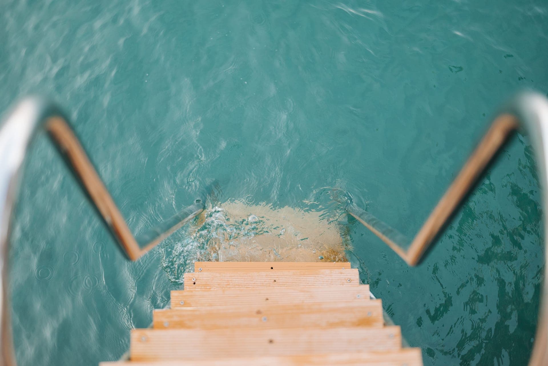 Wooden steps descending into clear turquoise water