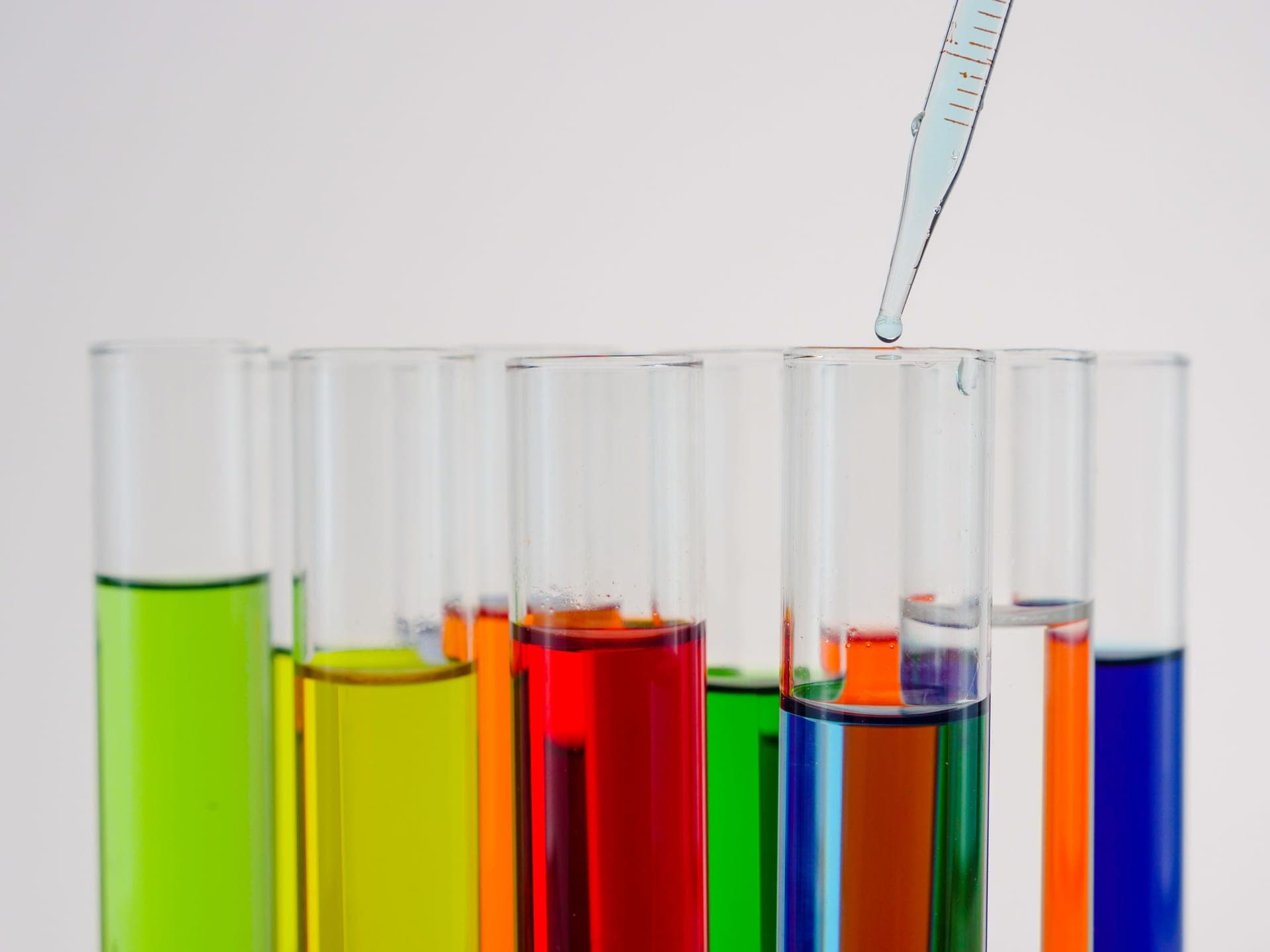 Test tubes of colored liquid with a pipette