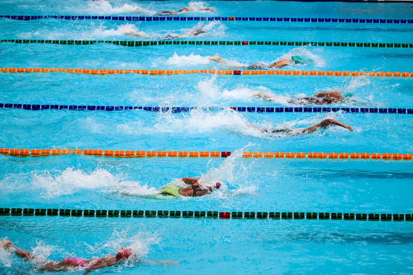 A busy swimming pool with several people in the water