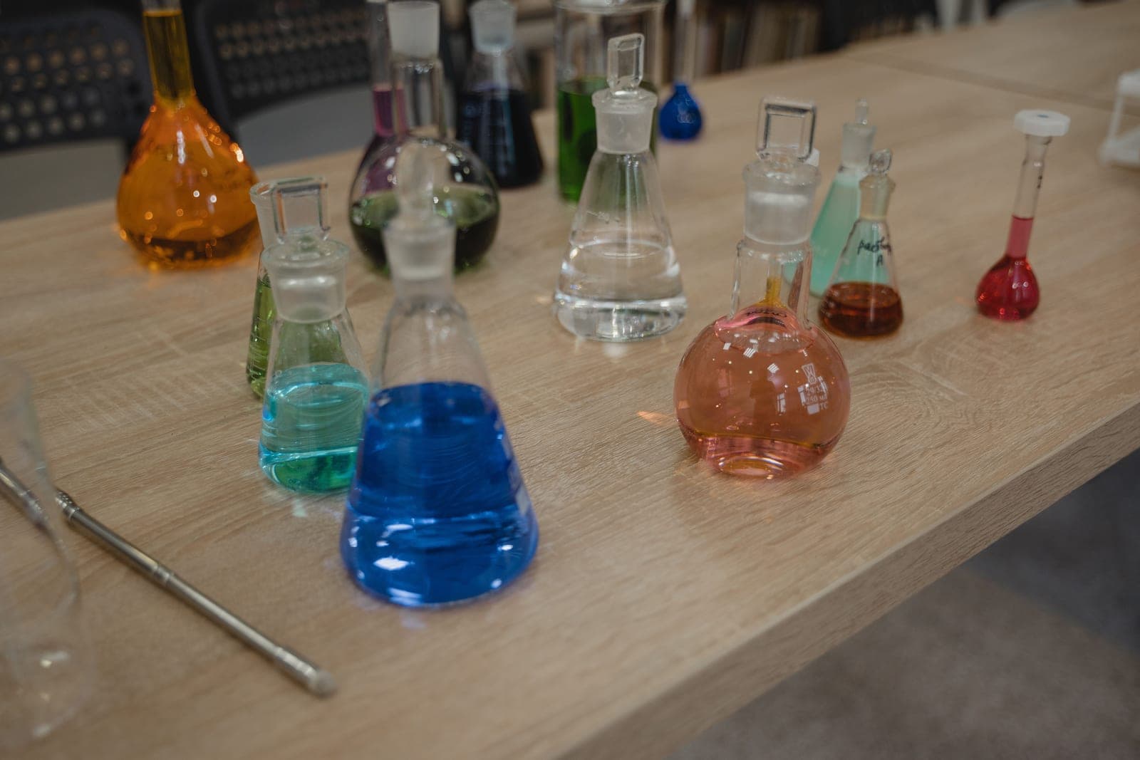Glass flasks of colored liquid on a bench