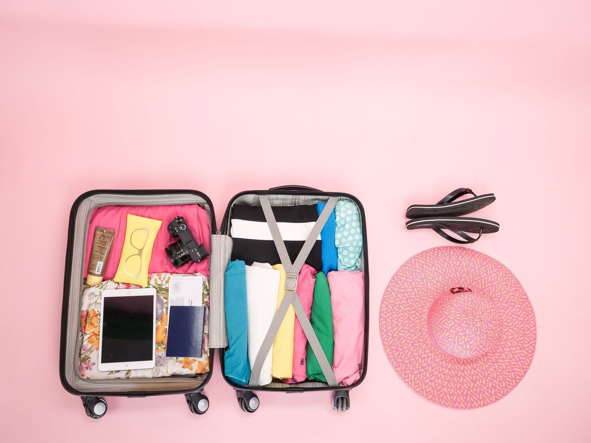 An open suitcase packed for a summer trip