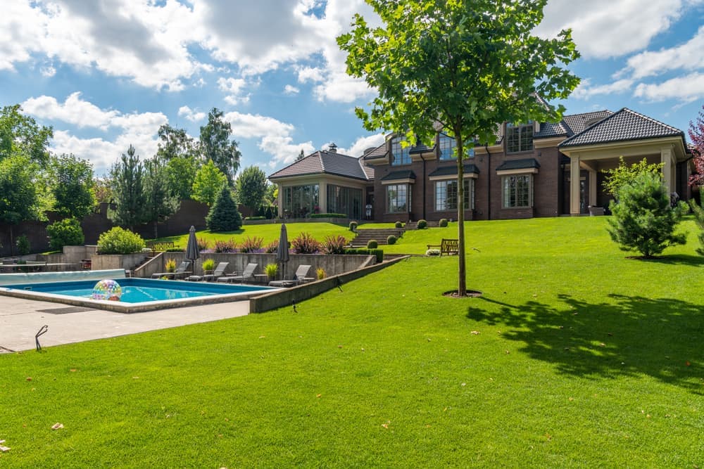 A large inground swimming pool beside a paved patio