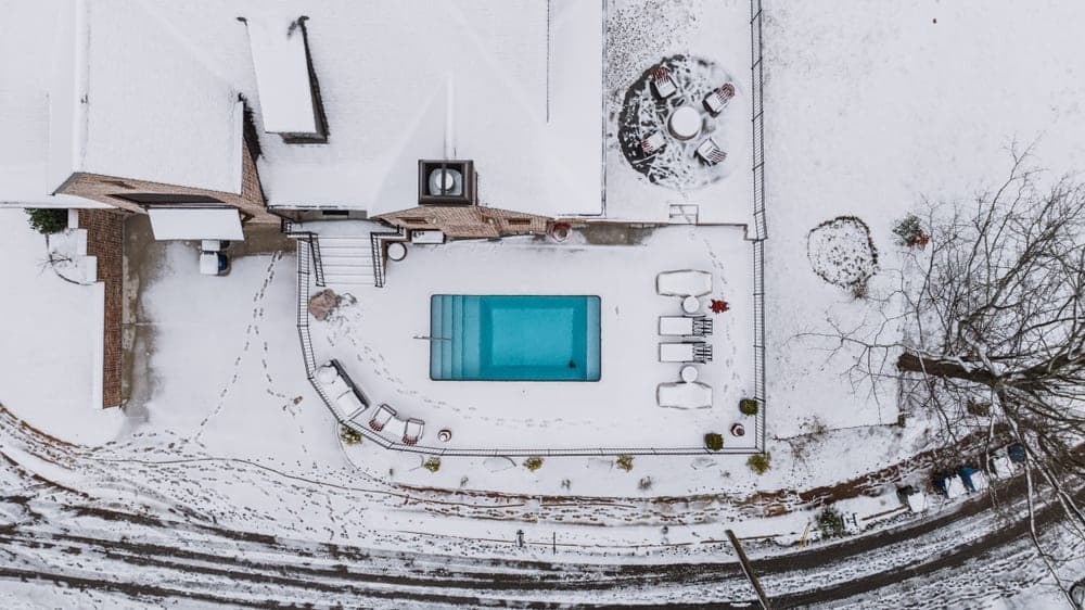 A frozen swimming pool surrounded by snow