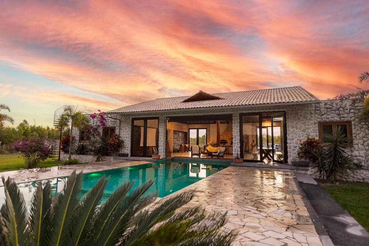 A backyard swimming pool photographed at sunset